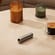 Ploom AURA front panel Lunar Silver accessory on a table.