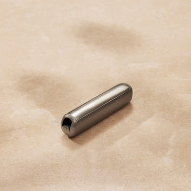 Close-up of a Ploom AURA front panel Lunar Silver accessory on a flat surface